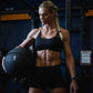 Athletic woman holding a wall ball in a gym setting.