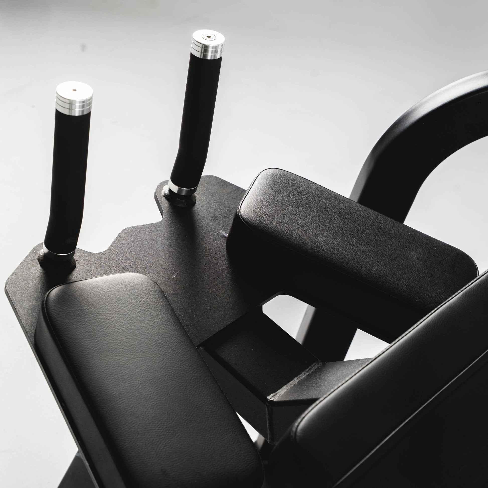 The grip handles and elbow pads on a plate loaded rear kickback machine