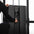 An athlete changing the weight resistance on a dual cable machine in a gym setting.