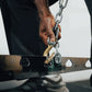 An athlete adjusting the height of a plate loaded belt squat machine.