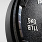 Close-up of a black weight plate with '5KG' and '11LB' text on a gray background
