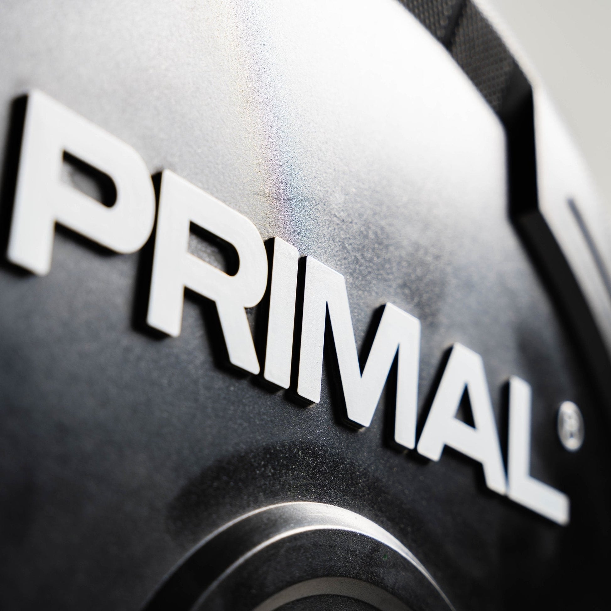 Close-up of a 'PRIMAL' logo on a metallic surface